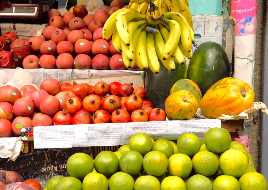 カトマンズのフルーツショップ　りんご、バナナ、ザクロ、パパイヤ、スイカ、柑橘類などのカラフルなディスプレイ