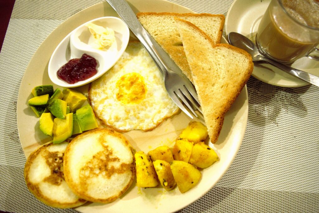 チトワンでのホテルの朝食プレート　目玉焼き、トースト、バター＆ジャム、パンケーキ、ポテト、アボガド