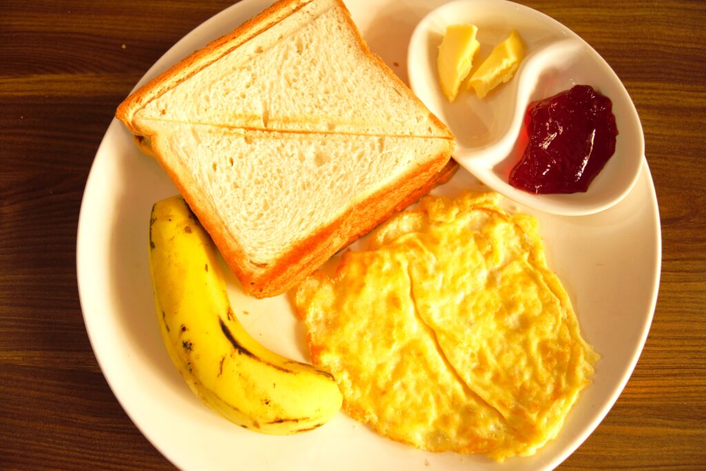 カトマンズのゲストハウスの無料朝食　トースト、オムレツ、バナナ、バター＆ジャム