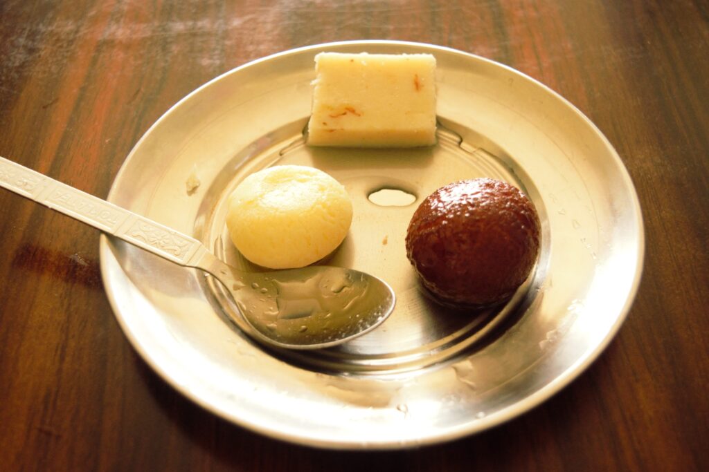 ポカラのスイーツショップにて　パルフィ（白い四角）・ラスグッラ（白い丸）・グラブジャムン（茶色い丸）　店主がインド人なのでインド系よりスイーツ